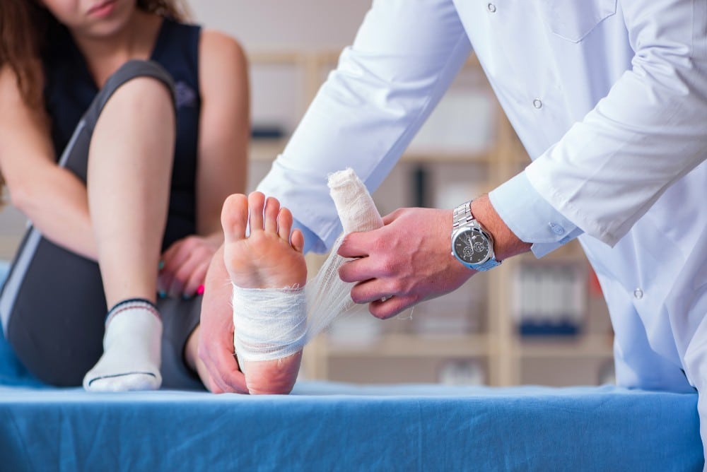 Podiatrist treating woman's sports foot injury