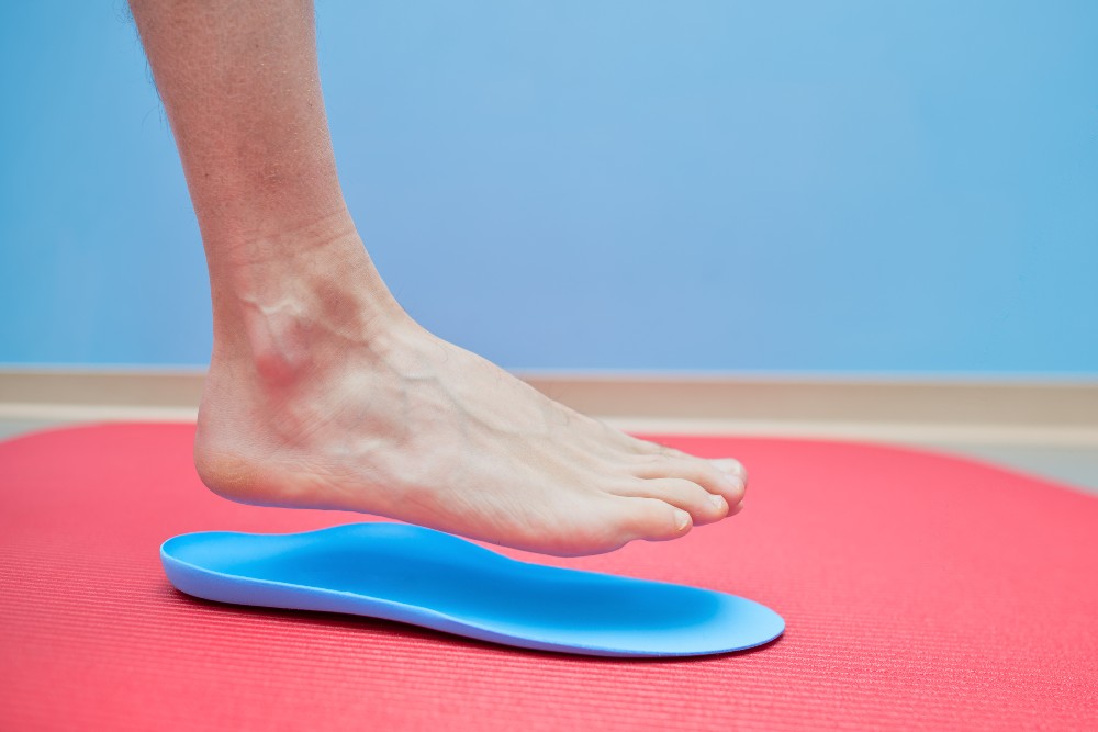 Person trying on orthotics to treat her flat feet